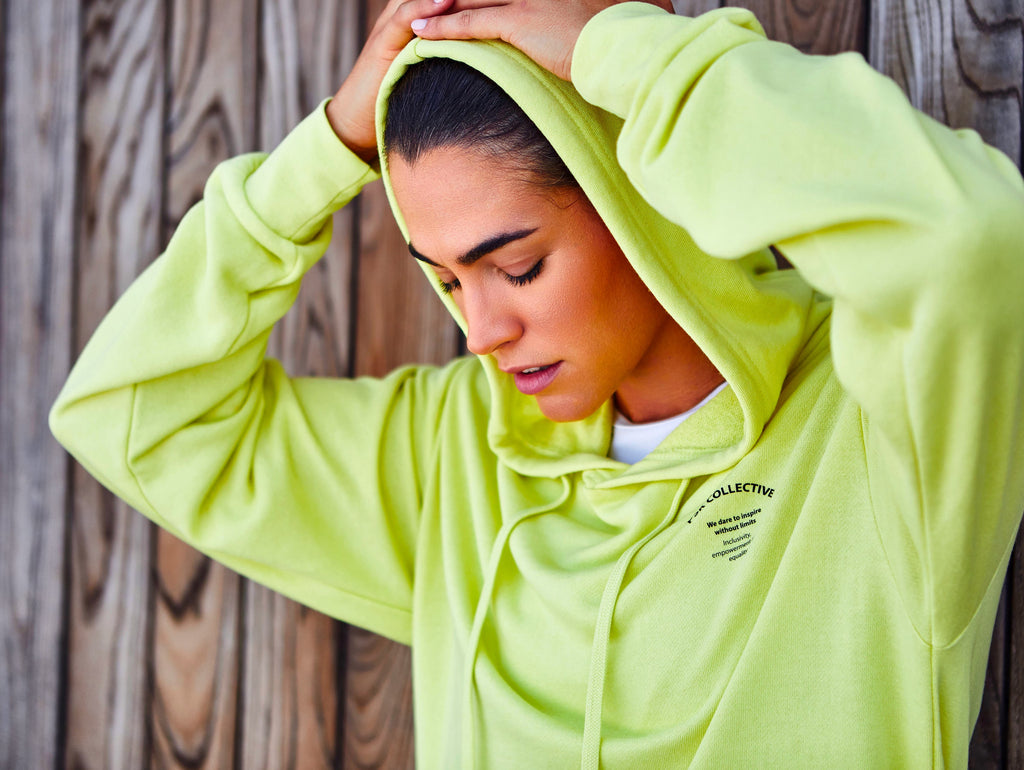 Woman wearing Pale Lime PSK Collective Hoodie from the Off the Court Collection