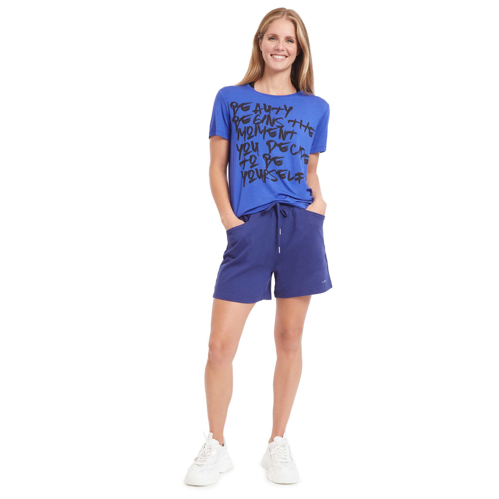 Woman wearing PSK Collective Calligraphic Tee in blue