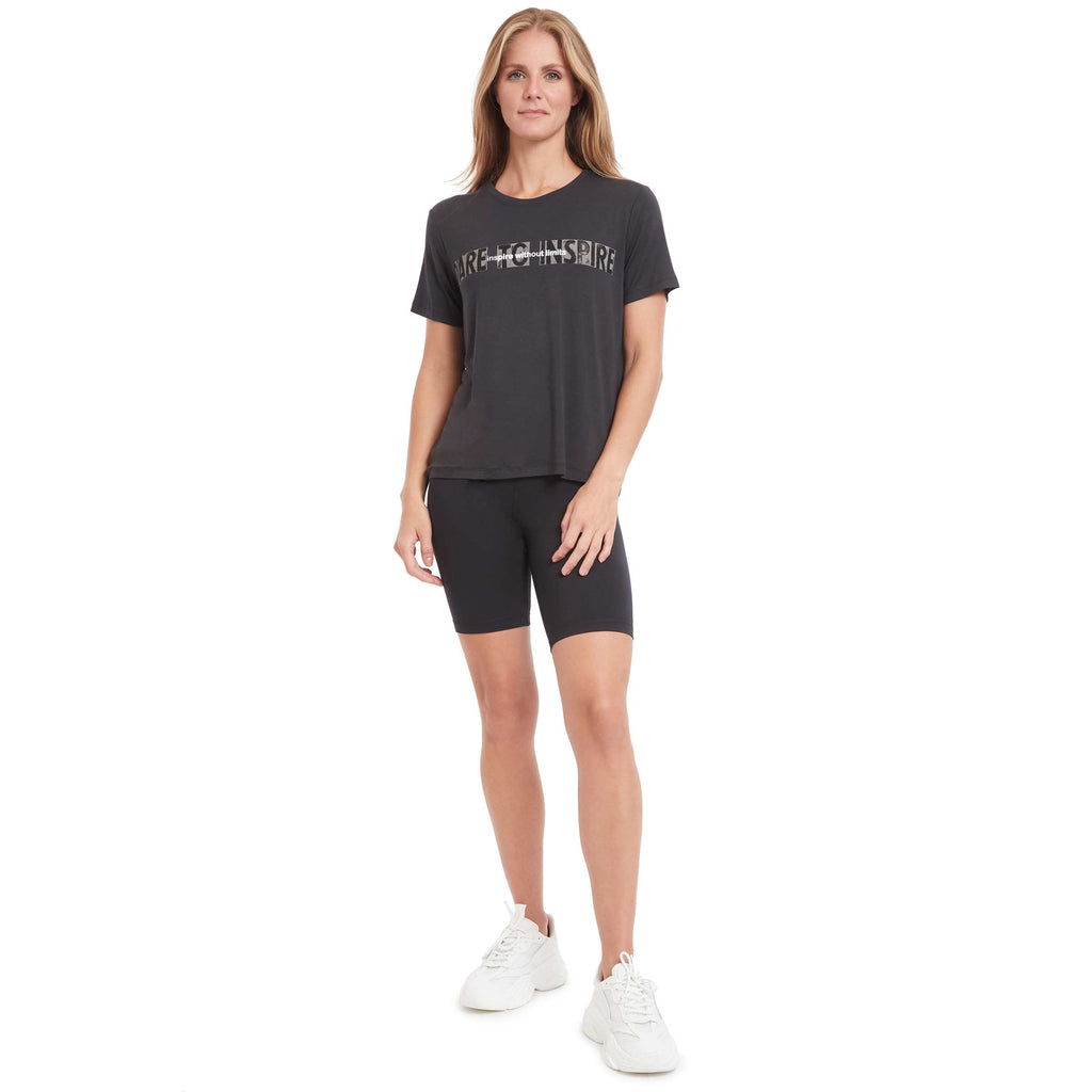 Woman standing wearing PSK Collective black Dare to Inspire Tee